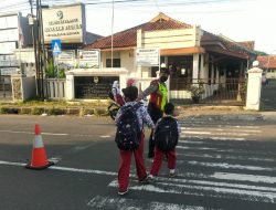 Peduli Keselamatan, Polisi di Majalengka Bantu Sebrangkan Anak Sekolah