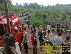 Polisi Membantu Membersihkan Bekas Luapan Air Saluran Irigasi yang Jebol Akibat Material, sehingga Menutupi Jalan Utama Cikondang Menuju Rancakalong